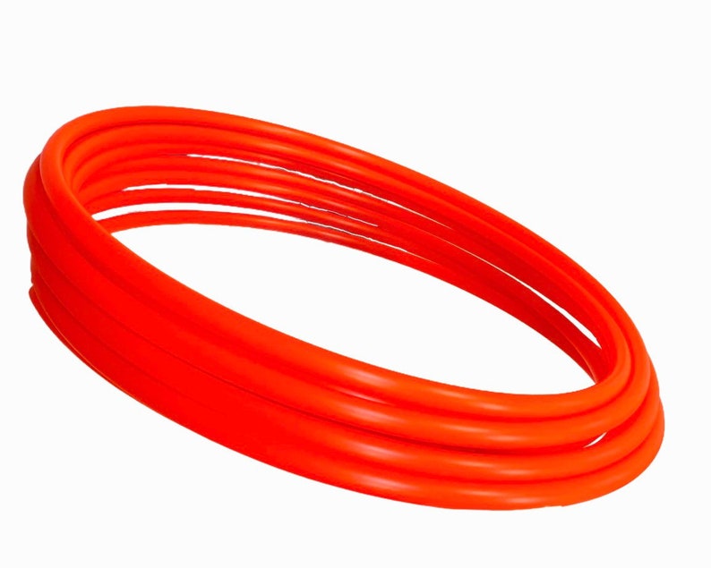May include: A set of four orange plastic hula hoops stacked on top of each other.