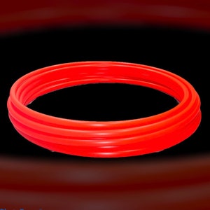 May include: A set of three red rubber rings, stacked on top of each other, forming a circle.