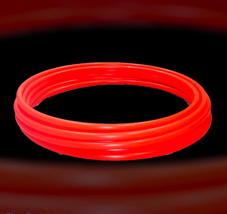 May include: A set of three red rubber rings, stacked on top of each other, forming a circle.