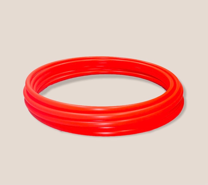 May include: A set of three red plastic hoops, stacked on top of each other.