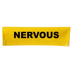Peut inclure: Une sangle en tissu jaune avec le mot "NERVOUS" imprimé en noir.