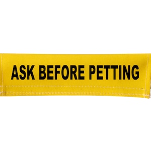 May include: Yellow fabric strap with black text that reads "ASK BEFORE PETTING".