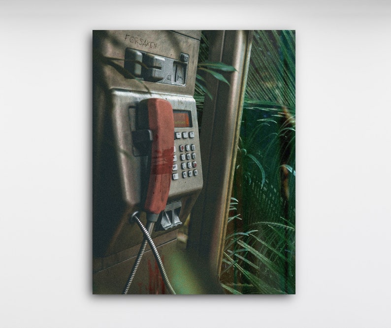 May include: A vintage, weathered payphone with a red receiver hanging off the hook. The phone is mounted on a wall with green foliage in the background. The phone has the word "FORSAKEN" printed on it.