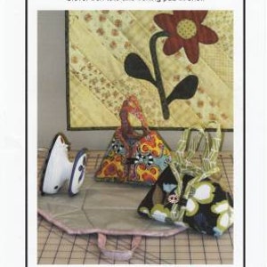 May include: A sewing pattern for a travel iron tote. The pattern includes a heat-resistant lining and is fat quarter friendly. The tote is sized to hold a mini travel iron. The pattern features a floral design with a red flower and green leaves.