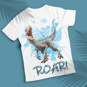 以下が含まれることがあります： 水色の水彩画の恐竜柄がプリントされた白いTシャツ。緑と青の文字で「ROAR!」と書かれている。