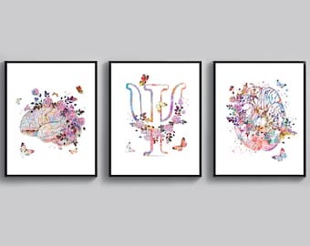 May include: Three watercolor prints featuring a brain, the Greek letter Psi, and a brain with flowers. The prints are framed in black frames and have a white background.