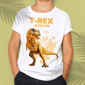 Op de afbeelding: Wit T-shirt met een gele afbeelding van een T-Rex-dinosaurus met de tekst "T-Rex Monster" erboven.