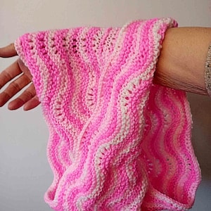 May include: A pink and white striped knitted scarf with a wavy pattern.