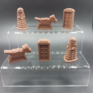 May include: Five brown 3D printed figurines on a clear acrylic display stand. The figurines are a Dalek, a TARDIS, and a K-9. The figurines are all about 5 cm tall.