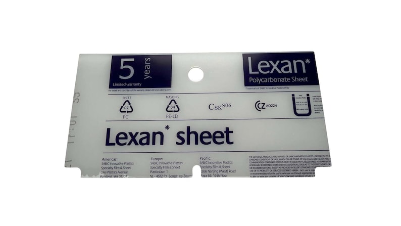 May include: A white Lexan polycarbonate sheet with a 5-year limited warranty. The sheet is labeled with safety and masking symbols, a CSK 506 code, and a CE mark with the number A0224. The sheet is also labeled with the text "Lexan sheet".