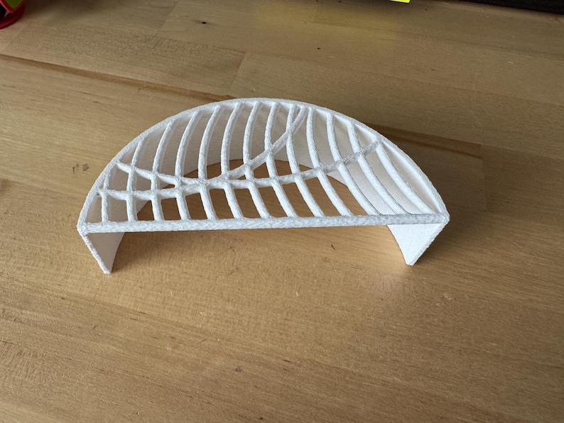 May include: White plastic 3D printed half dome with a lattice design.