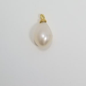 May include: A white pearl pendant with a gold bail. The pearl is teardrop shaped and has a smooth, glossy finish.