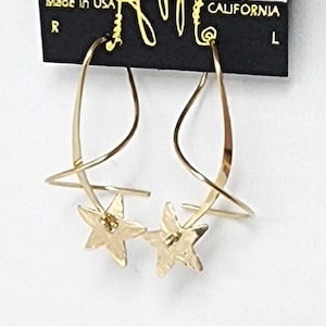 May include: Gold-toned earrings with a twisted wire design and two star-shaped charms. The earrings are displayed on a black card with the text "HARRY MASON" and "CALIFORNIA" printed on it.