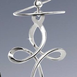 May include: Silver earring with a twisted design that forms a cross shape. The earring has a small bead at the top.