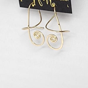 May include: Gold-toned wire earrings with a unique, abstract design. The earrings are made by Harry Mason Designer Jewelry, California.
