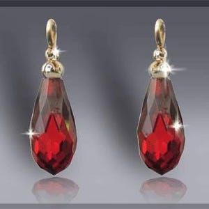 May include: A pair of red teardrop-shaped crystal earrings with gold-toned tops.
