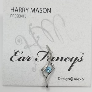 May include: Silver ear cuff with a blue gemstone and the text "Ear Fancys" and "Design©Alex S".