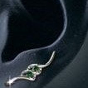 May include: A silver ear cuff with a twisted design and a small green gemstone.