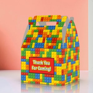 May include: A colorful party favor box with a Lego brick pattern. The box has a handle and says "Thank You For Coming!" on the front.