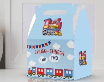 May include: A blue and red train-themed favor box with a handle. The box has a picture of a red train with yellow wheels and a blue smoke stack. The text on the box says "Chugga Chugga Two Two".