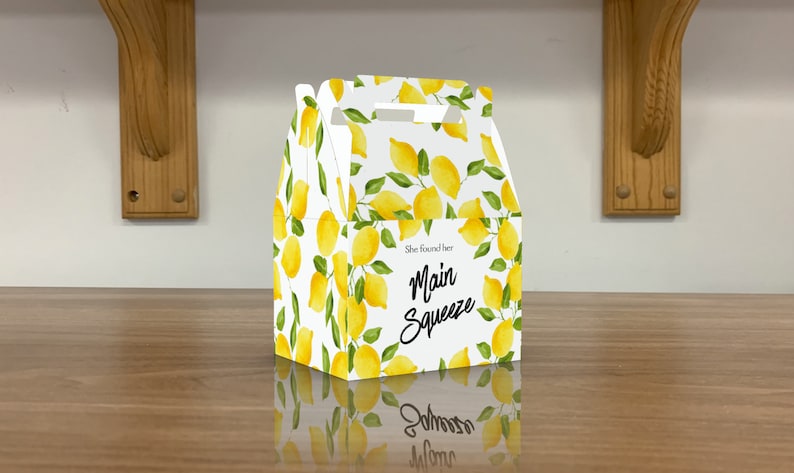 Puede incluir: Una caja de regalo blanca con estampado de lim&oacute;n y el texto "She found her Main Squeeze".
