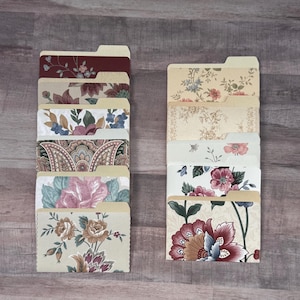May include: A collection of ten file folders arranged in two stacks, each featuring distinct floral and paisley patterns in various color palettes including burgundy, cream, pink, blue, and green, with tabbed tops for organization.