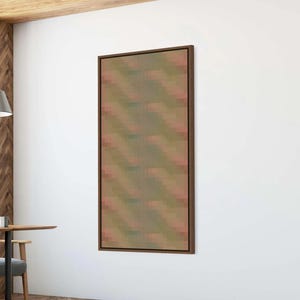 May include: A rectangular wall art piece featuring a vertical orientation and a dark brown frame. The artwork displays a repeating pattern of small, muted, pixelated squares in shades of olive green, soft pink, and muted blue, arranged in diagonal lines.