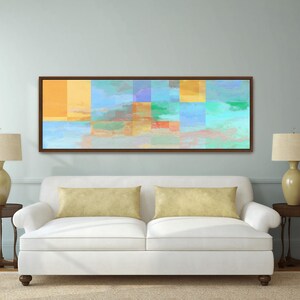 May include: A rectangular wall art piece featuring an abstract composition of overlapping geometric blocks and soft color washes in shades of yellow, orange, turquoise, light blue, and green, enclosed within a thin dark brown wooden frame.