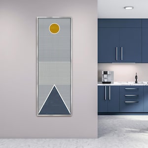 May include: A framed abstract art piece with a geometric design. The artwork features a yellow circle, vertical blue and white stripes, horizontal lines, and a blue triangle. The piece is in a silver frame and hangs on a light gray wall.