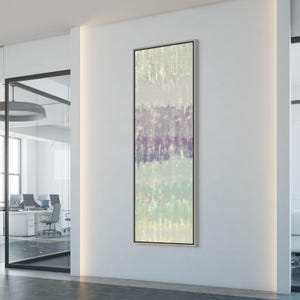 May include: Vertical abstract painting with a silver frame. The artwork features horizontal bands of color in shades of green, purple, and beige. The brushstrokes are visible, creating a textured effect. The painting is displayed on a white wall.