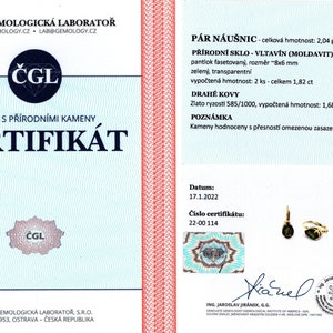 May include: A certificate of authenticity for a pair of earrings with green Moldavite stones. The certificate is from the Czech Gemological Laboratory and states the stones weigh 1.82 carats and are set in 14k gold. The certificate number is 22-00 114 and the date is 17.1.2022.