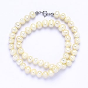 May include: A strand of cream-colored pearl beads with a silver clasp.