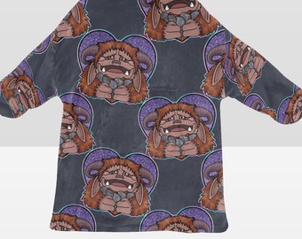 Può includere: Una coperta con cappuccio di colore grigio scuro con un motivo ripetuto di creature pelose marroni con cuori viola. Le creature hanno occhi grandi e tengono pietre nelle loro mani.