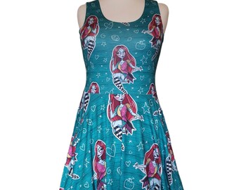 May include: A teal sleeveless dress with a print of a cartoon character with red hair and a black and white striped dress. The print is repeated all over the dress and includes hearts, stars, and other doodles.