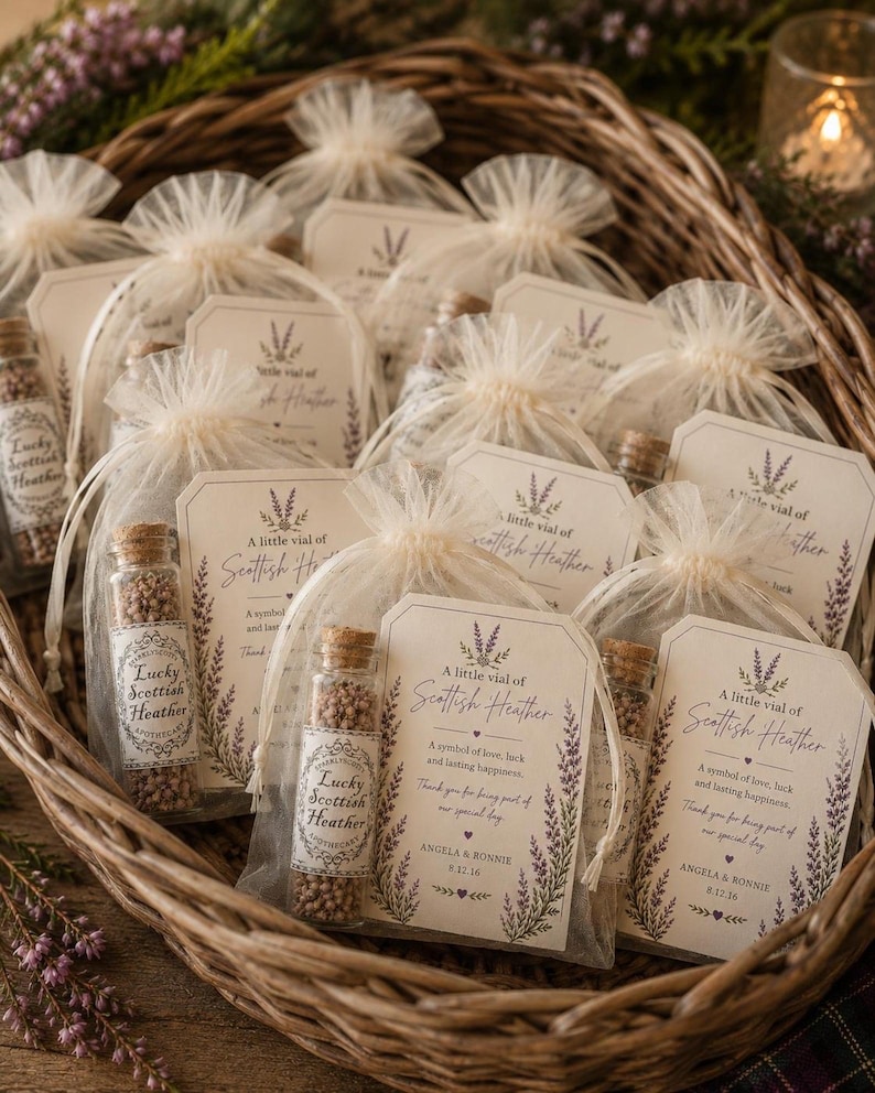 May include: A collection of small glass vials filled with tiny brown particles, each sealed with a cork stopper and tucked into a sheer cream organza drawstring bag. Each bag includes a rectangular card labeled A little vial of Scottish Heather.