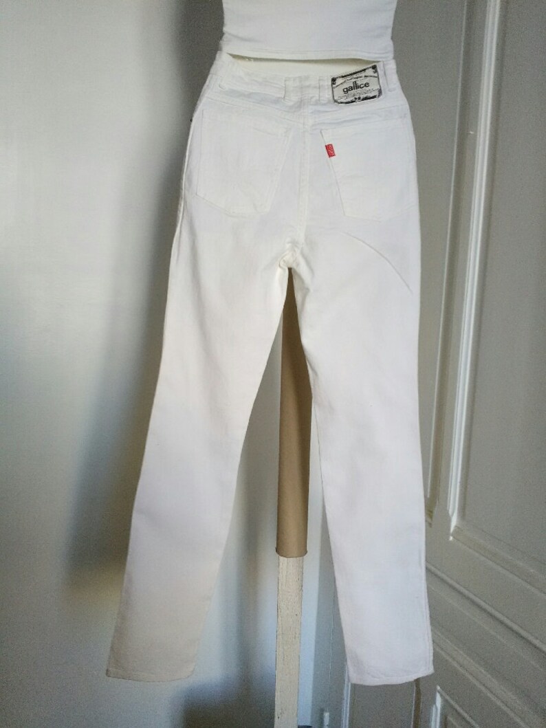 May include: White high-waisted jeans with a small "gallice" label on the back pocket.