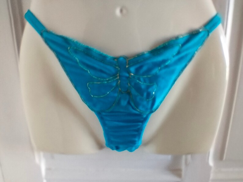 May include: Turquoise blue lace underwear with a gold butterfly design.