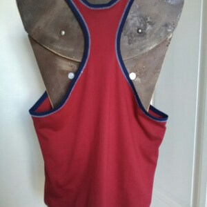 May include: Red sleeveless tank top with a navy blue trim around the neck and armholes.