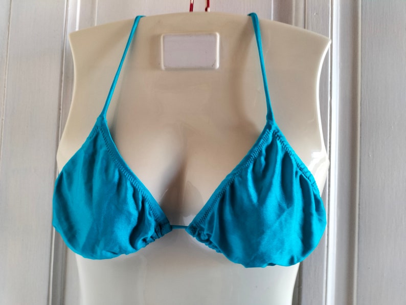 May include: A turquoise bikini top with adjustable straps.