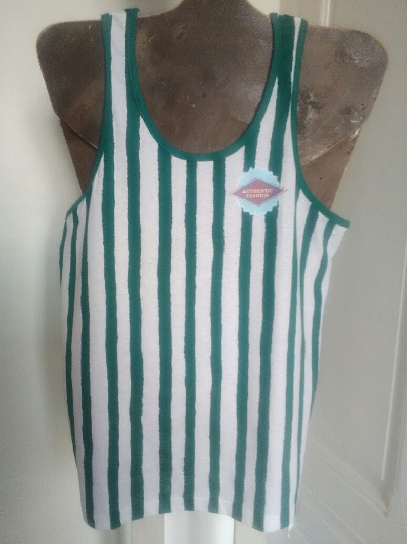 May include: A white and green striped tank top with a small, blue diamond-shaped tag that says "Authentic Fashion".