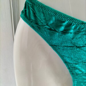 May include: Teal green silky underwear with a delicate lace trim.