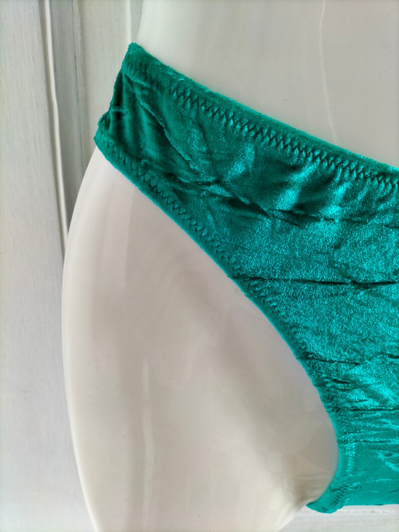 May include: Teal green silky underwear with a delicate lace trim.