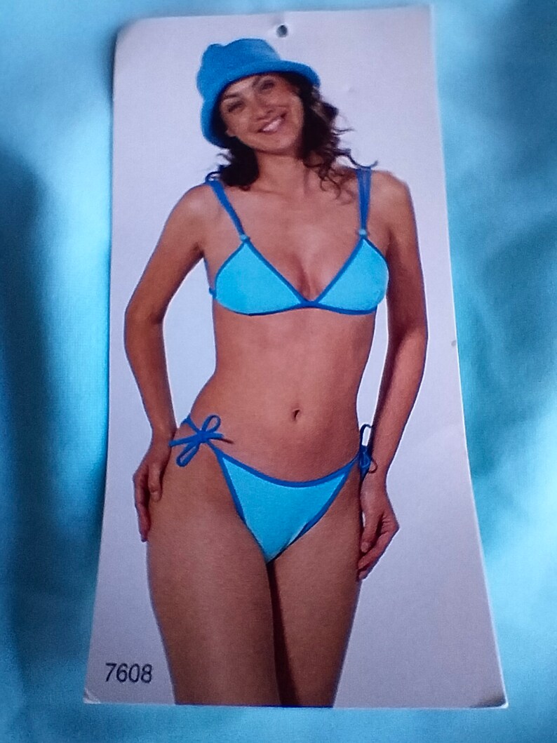 May include: A blue bikini with a triangle top and a tie-side bottom. The bikini is on a white background with the number 7608 printed on the bottom.