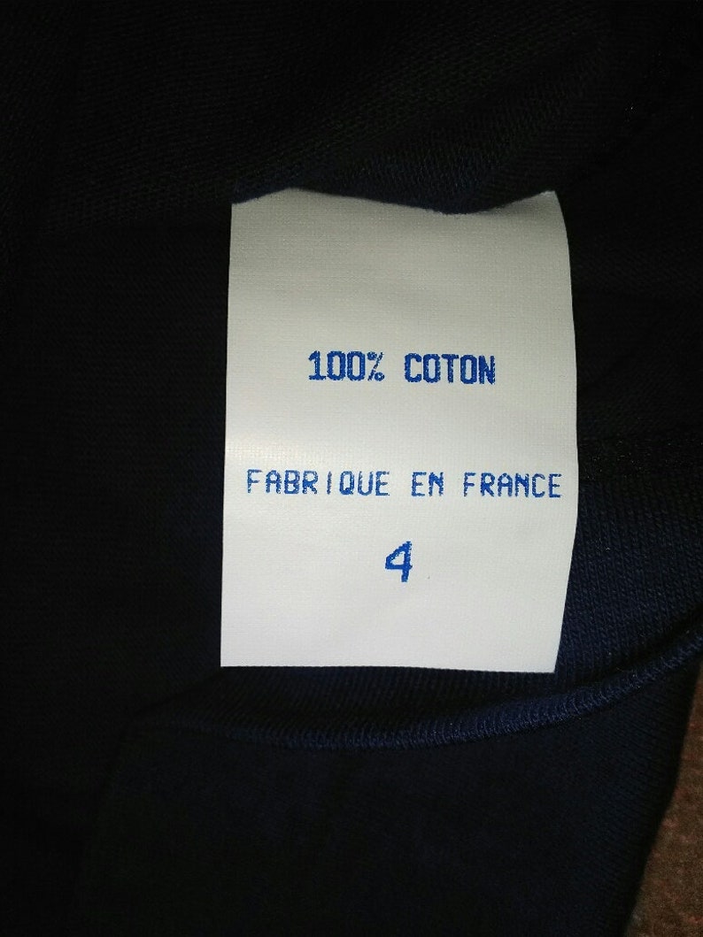 May include: White tag with blue text that reads "100% COTON FABRIQUE EN FRANCE 4".