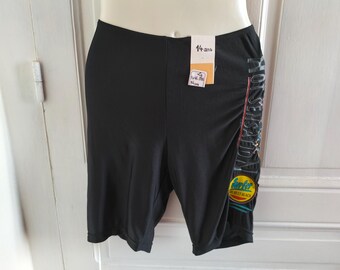 Puede incluir: Pantalones cortos deportivos negros con un estampado gráfico vertical en el lado izquierdo con el texto "HOT SENSATION" y un emblema circular "Surfer ON BEST BEACH". Tiene una etiqueta blanca con el texto "14 ans" y "146-158 cm".