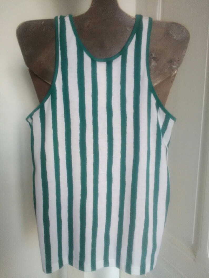 May include: A white tank top with green vertical stripes. The tank top is sleeveless and has a scoop neck.