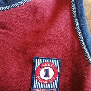 May include: Red shirt with a blue and white striped patch that says "BASIC BALL SPORTS ENERGY" with a red circle and the number "1" in white.