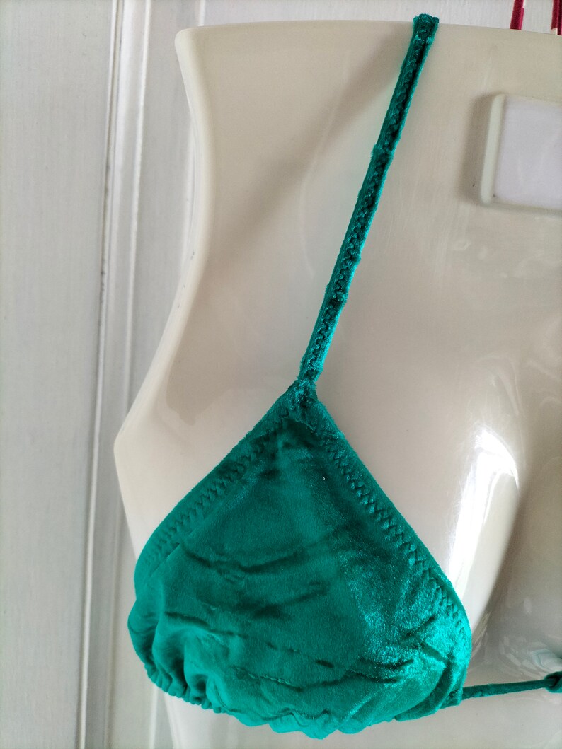 May include: A teal green satin triangle bikini top with adjustable straps.