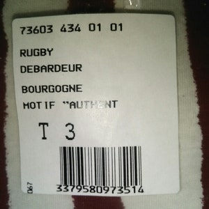 May include: White and burgundy striped fabric with a white tag attached. The tag has the text "73603 434 01 01", "RUGBY", "DEBARDEUR", "BOURGOGNE", "MOT IF "AUTHENT", "T 3" and a barcode with the number "3379580973514".