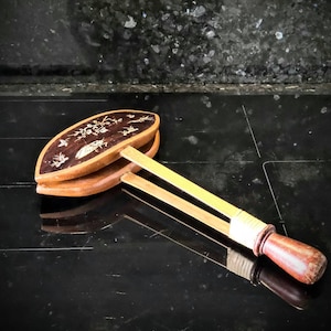 Puede incluir: Un abanico de mano de madera con un diseño decorativo de flores y pájaros. El abanico está cerrado y tiene un mango de madera marrón.